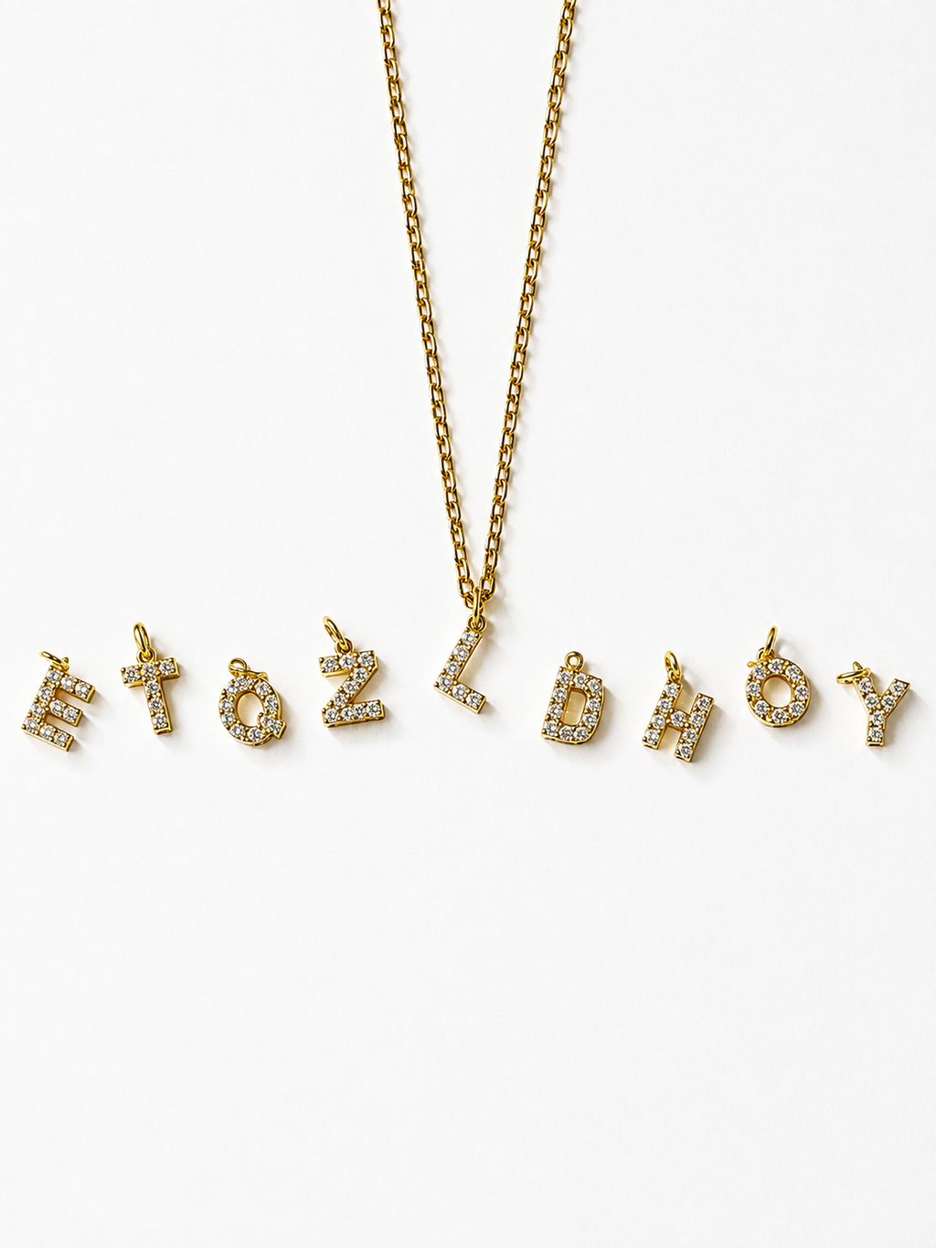 A 18K gold-plated gold chain necklace with gold initial pendants paved with small clear rhinestones